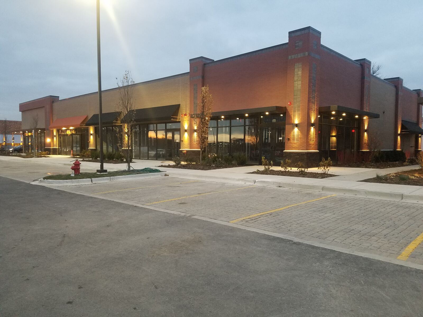 Retail center exterior at dusk with wall pack and accent lighting